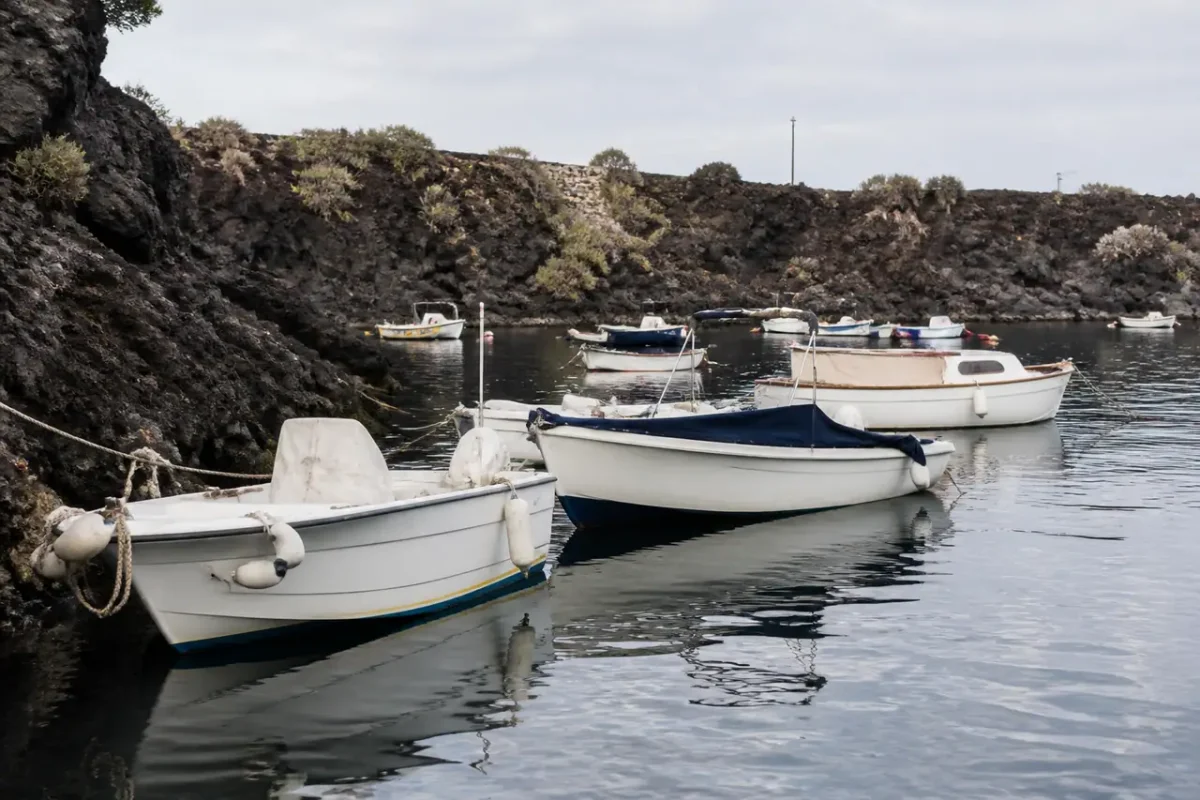 Bateaux blancs amarres dans un petit port volcanique