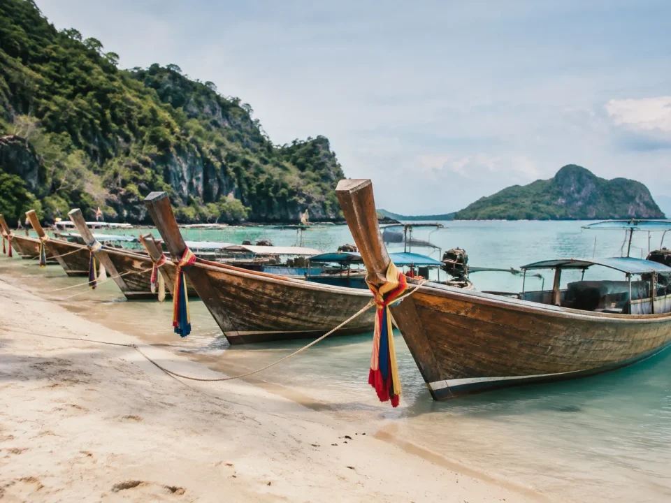 Bateaux longtail en bois alignés sur sable blanc