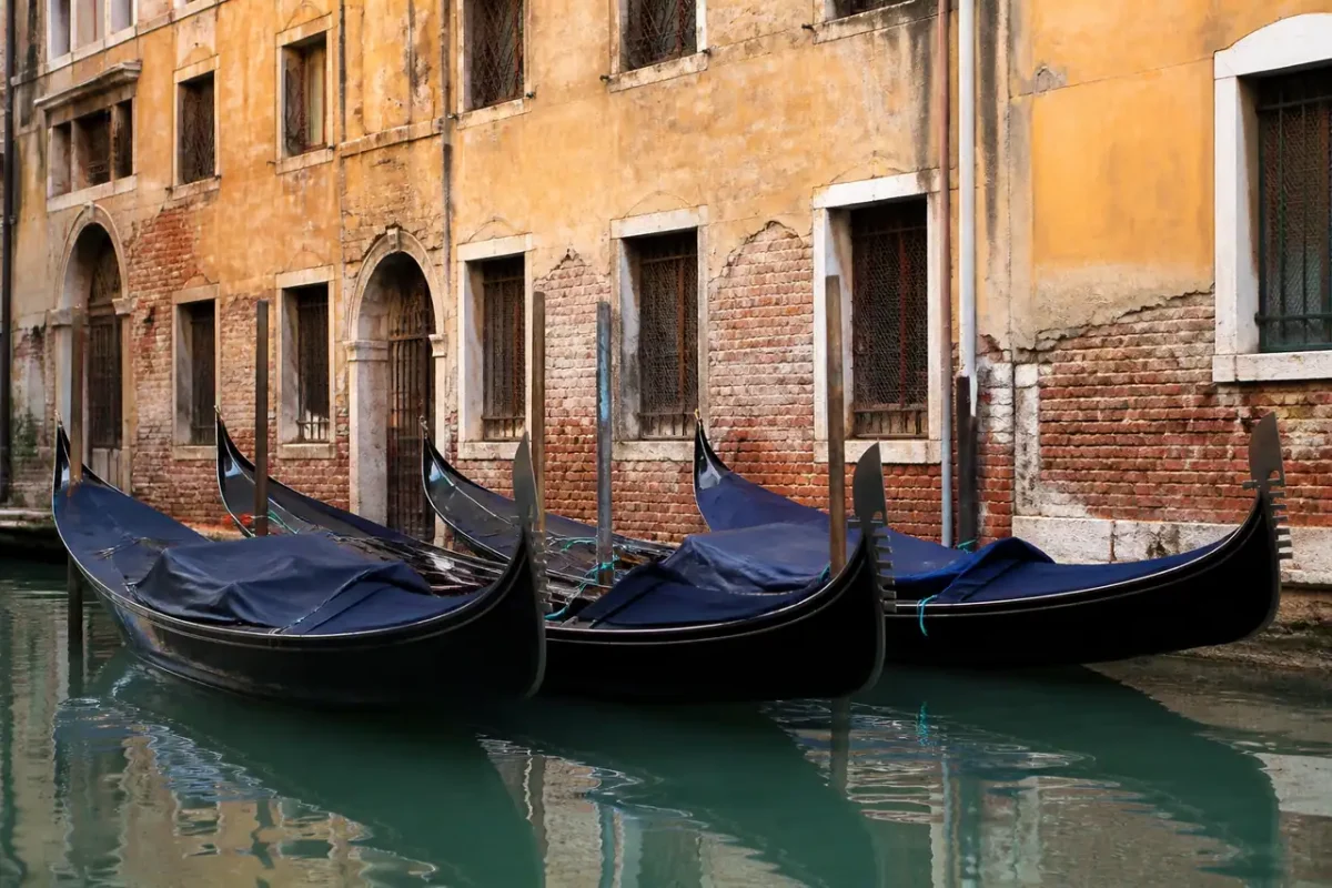 Gondoles noires amarrees devant des facades ocres