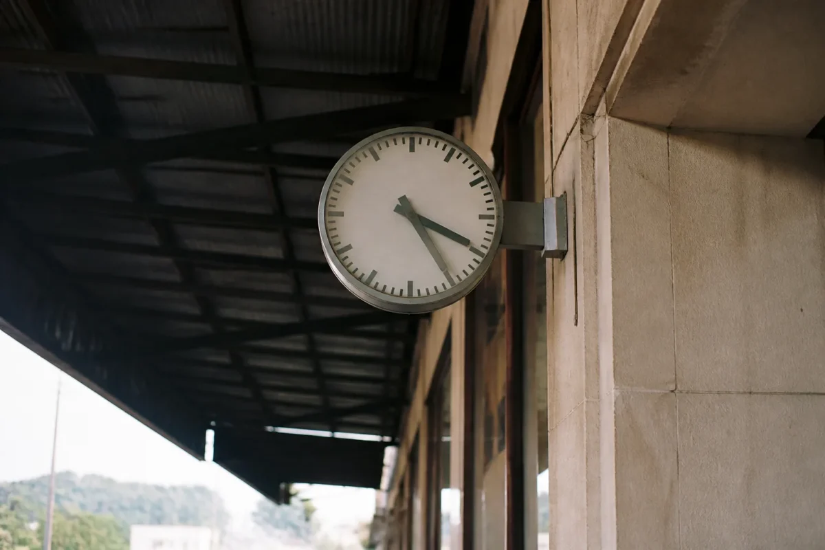 Grande horloge blanche au-dessus du quai de gare