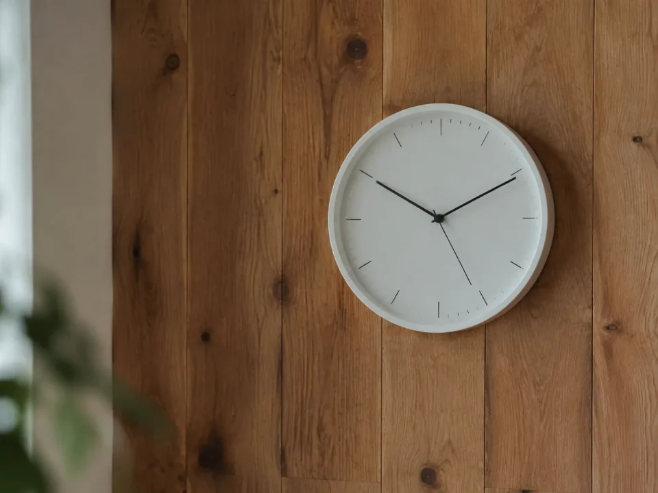 Horloge murale blanche posée sur un mur en bois