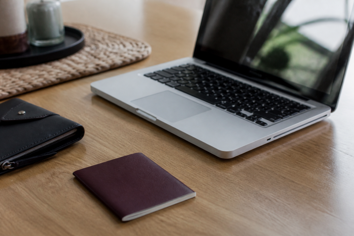 Passeport et ordinateur portable ouvert sur bureau