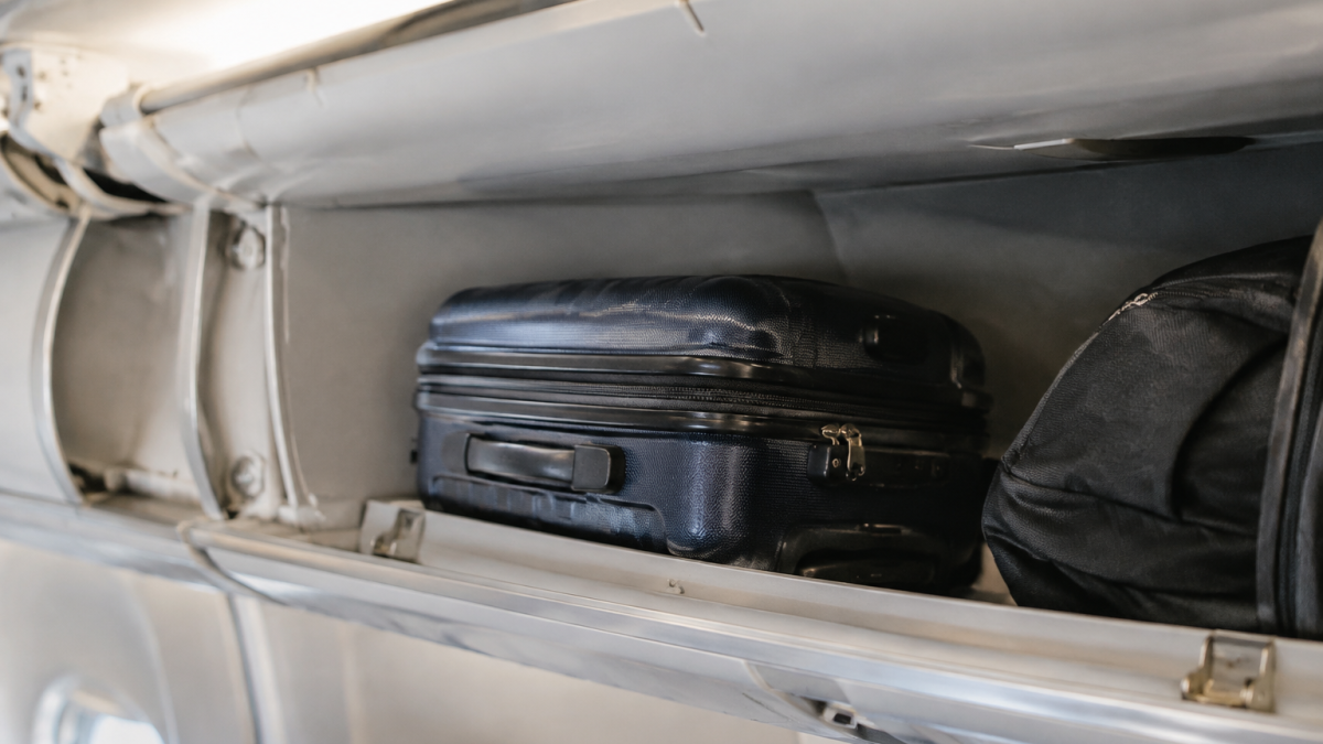 Valise compacte placee dans compartiment bagage avion